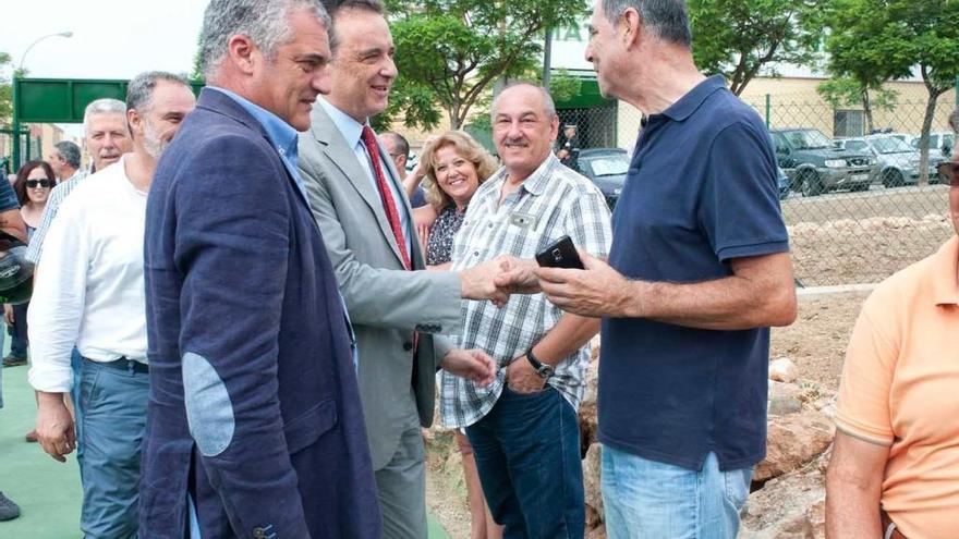 El edil César Carrasco, el consejero Javier Carnero y el alcalde José Ortiz entregan las parcelas.