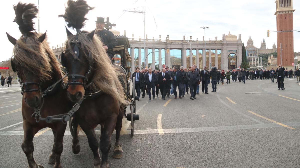 Un cotxe fúnebre amb cavalls guia la manifestació per escenificar el funeral de les VTC tradicionals a la Plaça Espanya de Barcelona