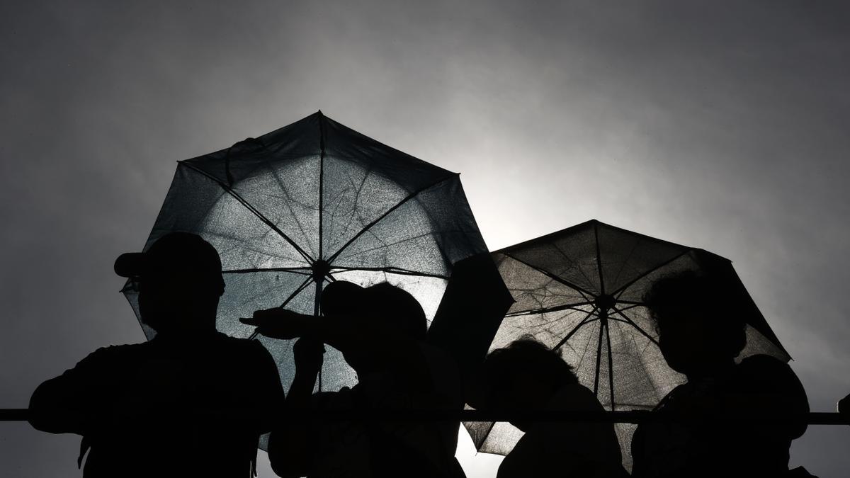 Varias personas con paraguas.