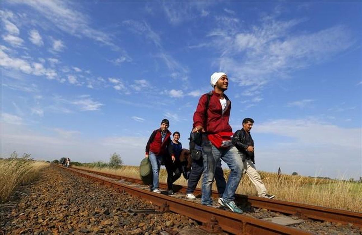 Un grup d’immigrants caminen per la via del tren després de travessar la frontera entre Sèrbia i Hongria a Roszke.