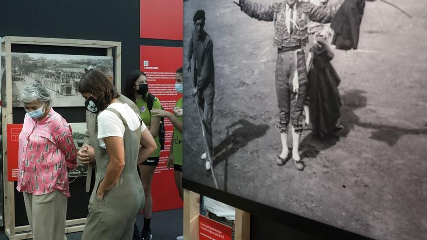 Ana González pasa delante de una fotografía de toros tomada en Gijón.