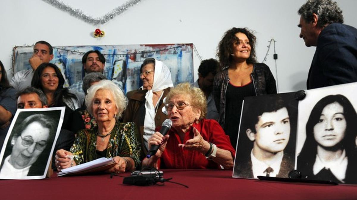 La presidenta de las Abuelas de la Plaza de Mayo, Estela de Carlotto (izquierda), anuncia la recuperación de la nieta 110, ante unas fotografías de los padres de la joven (derecha) y de la abuela (izquierda), todos fallecidos ya, este jueves.