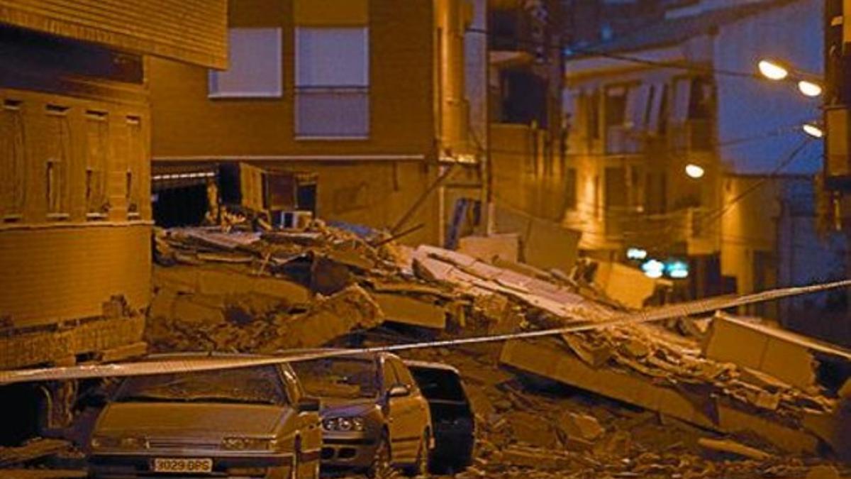 Coches atrapados bajo las ruinas de uno de los edificios destruidos.