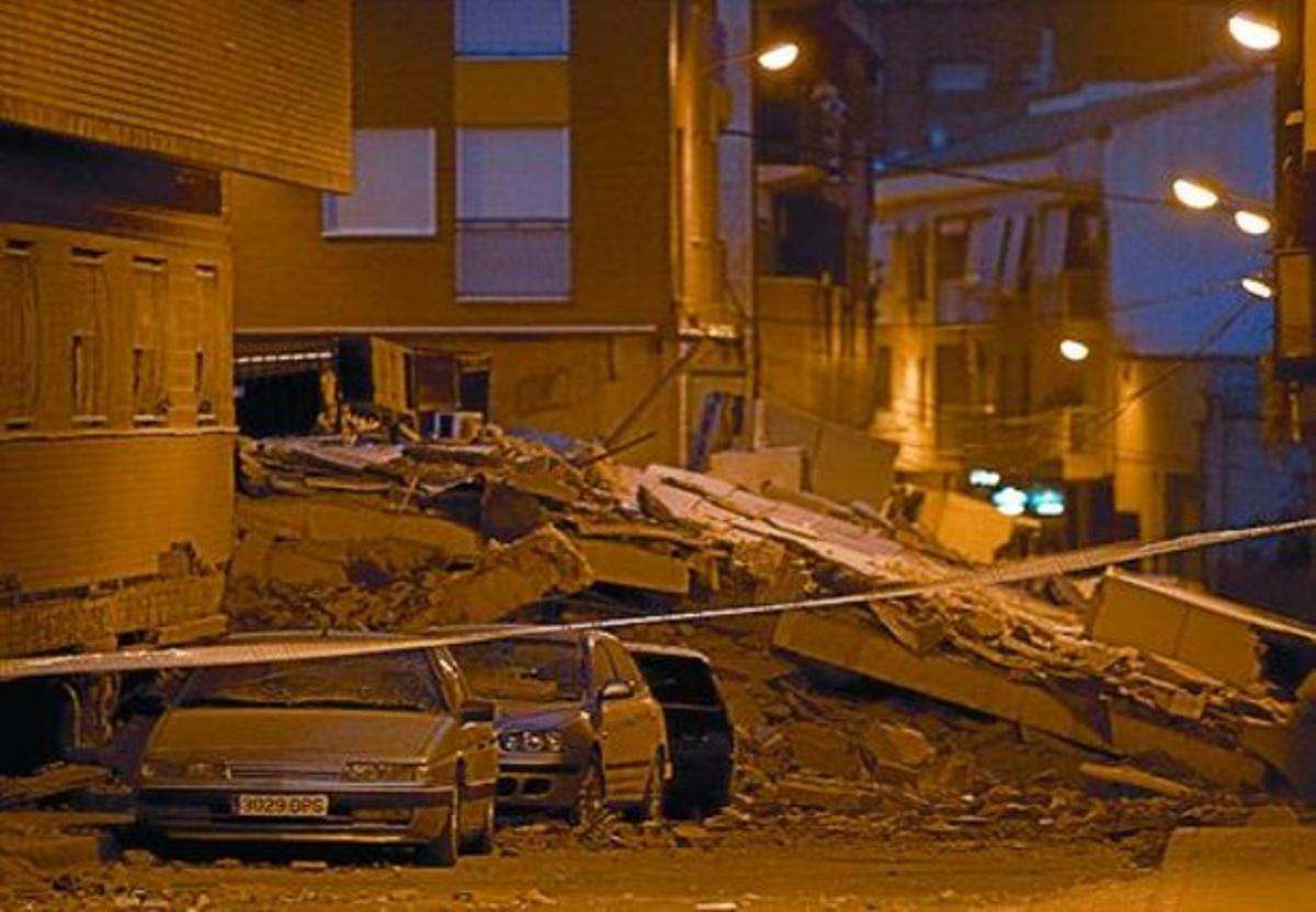 Cotxes atrapats sota la runad’un dels edificis destruïts.