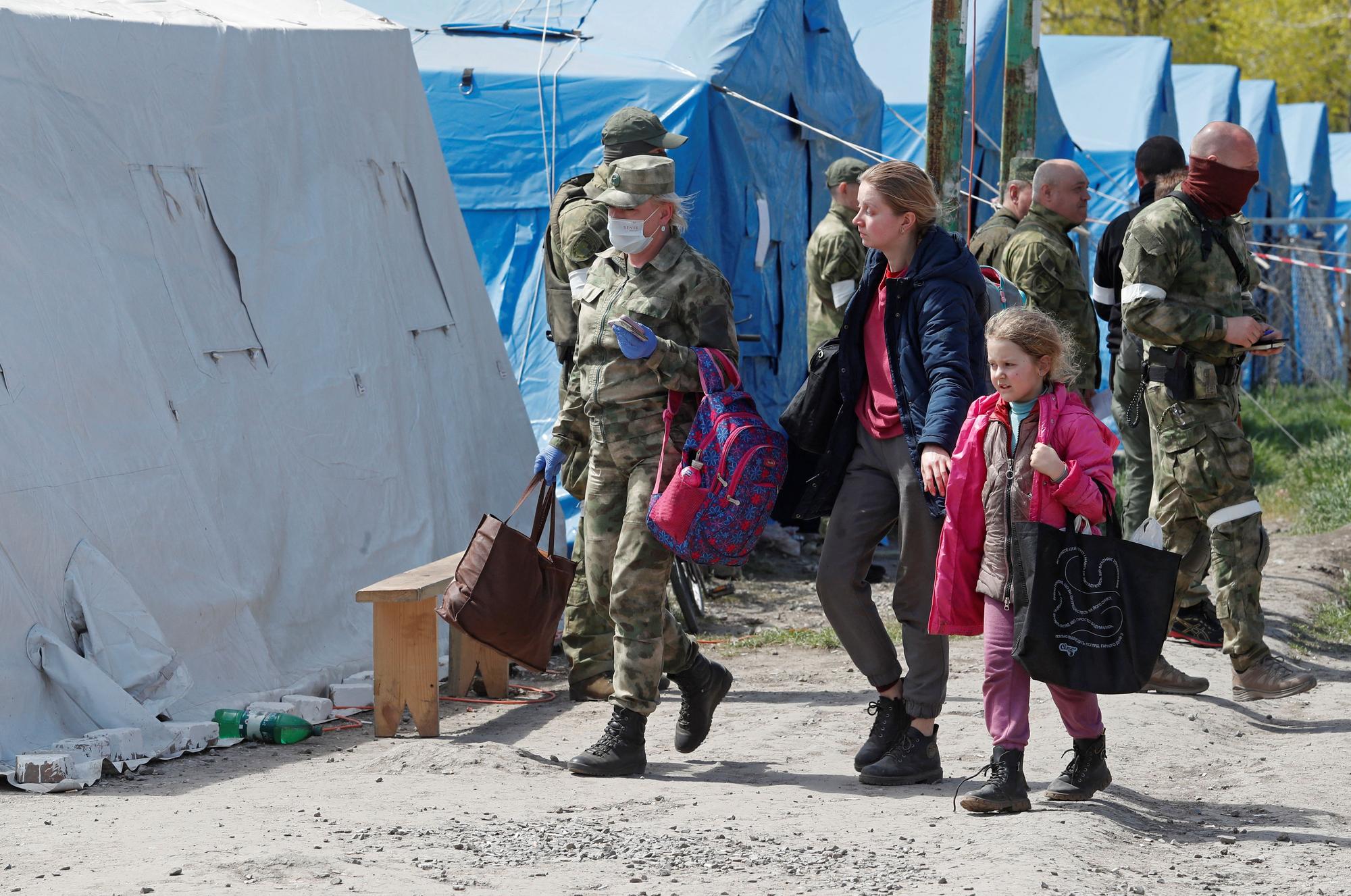 Civilians who left the area near Azovstal steel plant in Mariupol walk at a temporary accommodation centre in Bezimenne