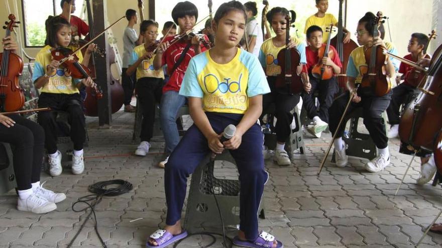 Varaporn, cantando rodeada de la orquesta de niños.