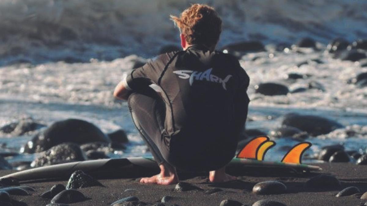 Un surfero, a la orilla de la playa.