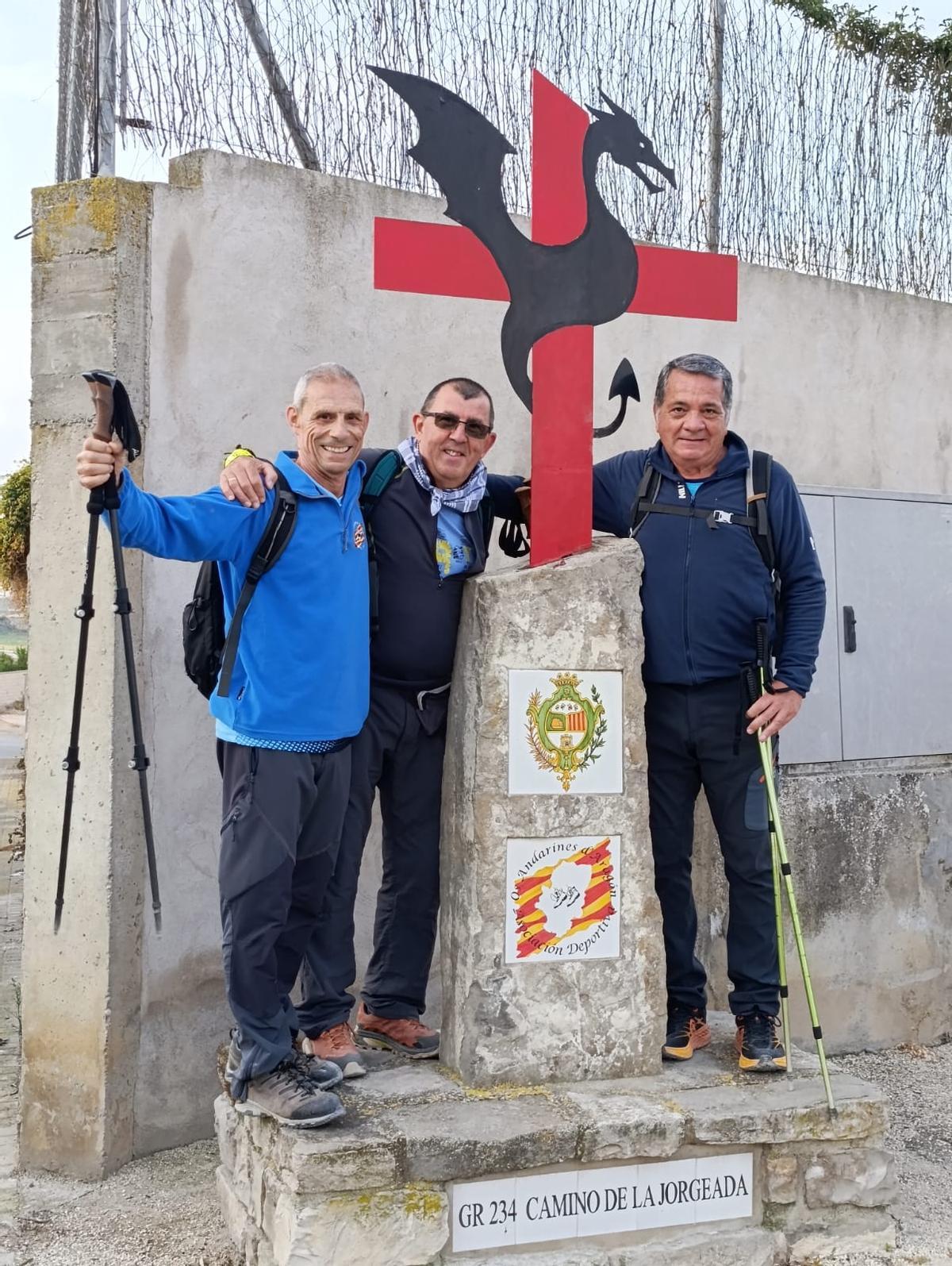 Tres participantes, junto a uno de los nueve dragones que jalonan el camino.