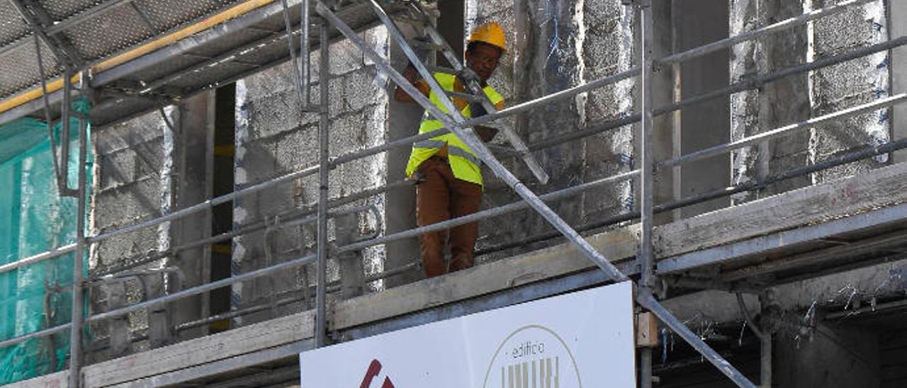 Un trabajador de la construcción desarrolla su labor en un andamio.