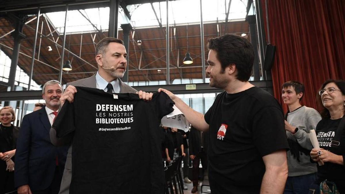 El escritor británico David Walliams recibe una camiseta reivindicativa de los bibliotecarios de Barcelona, este lunes en huelga, durante el pregón de Sant Jordi 2024.