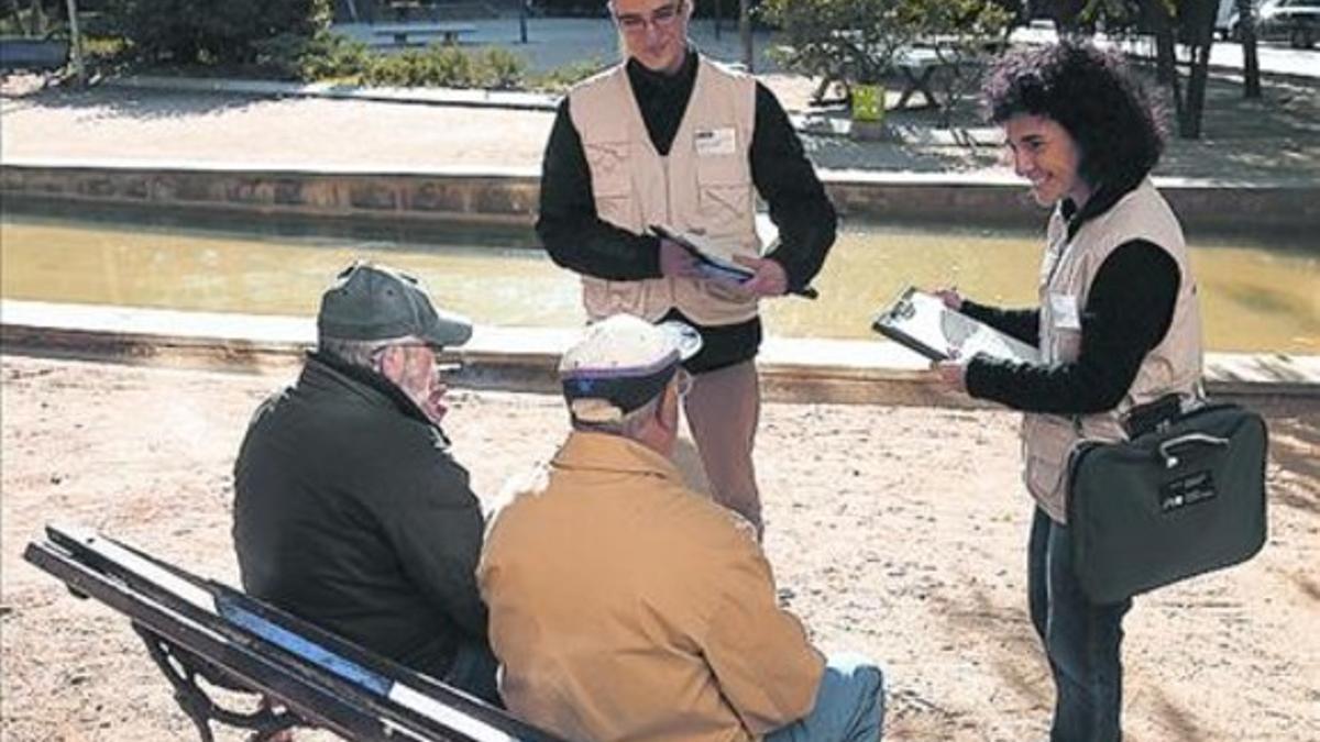 Informadores ambientales hablan con vecinos en la plaza de Les Corts.