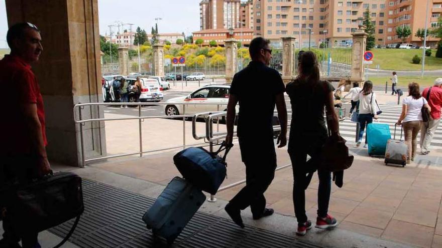 Varios viajeros salen de la estación de tren.