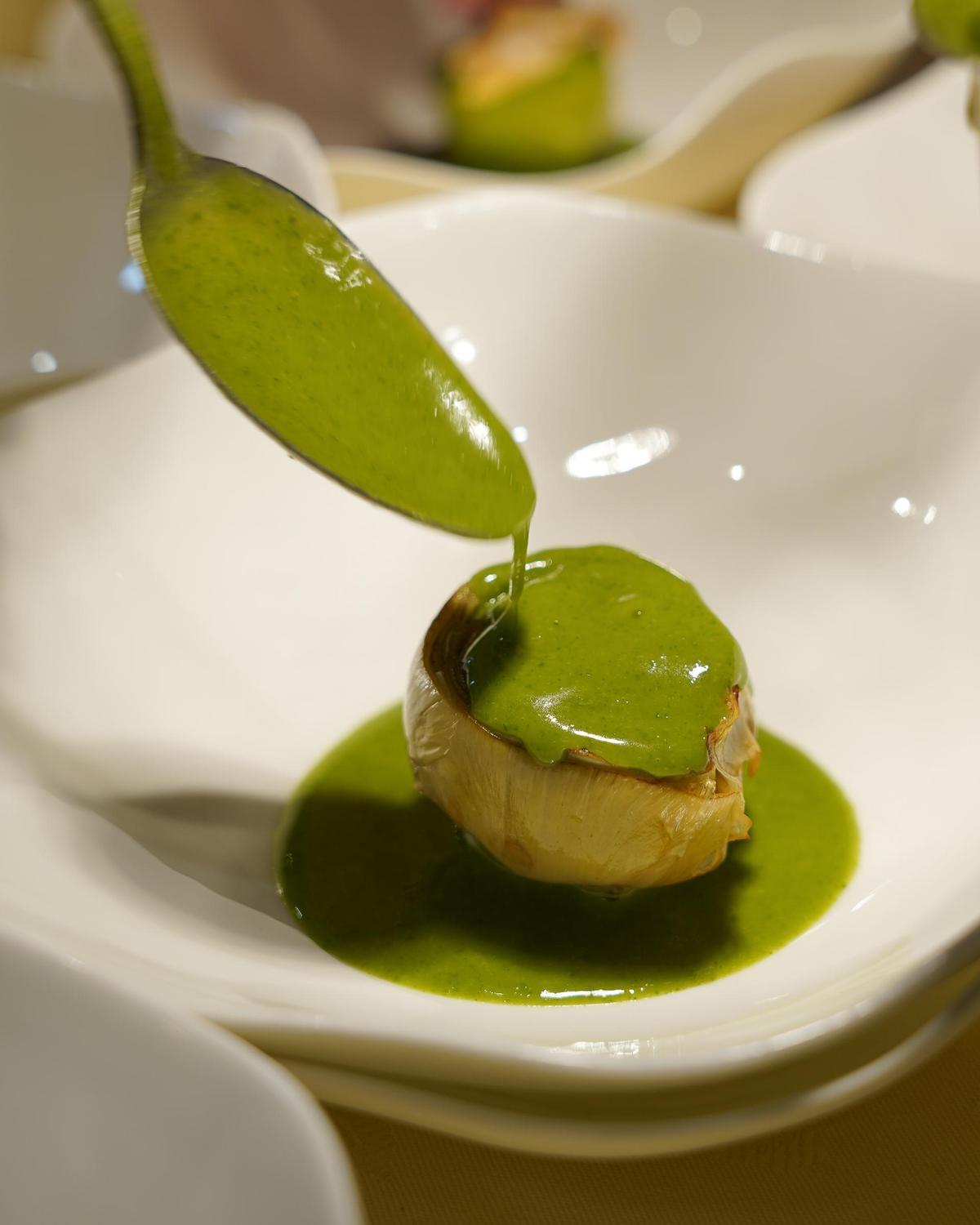 Carxofa brasejada amb favetes, cloïsses i salsa verda.