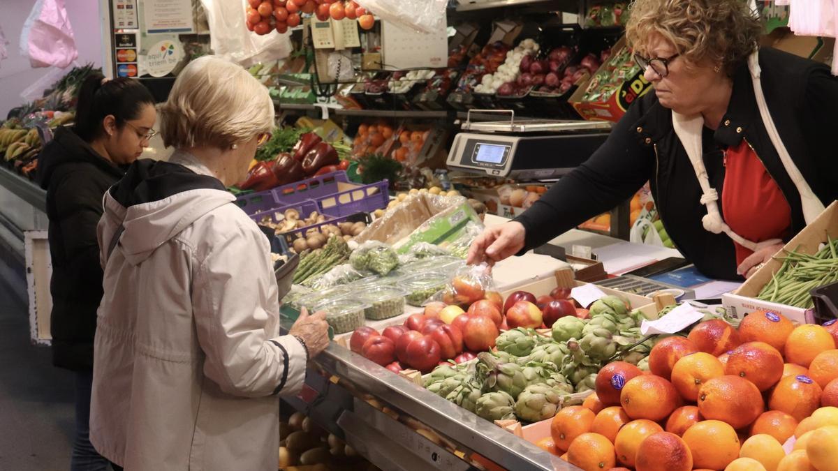 Clients comprant fruita en una parada del Mercat del Lleó de Girona