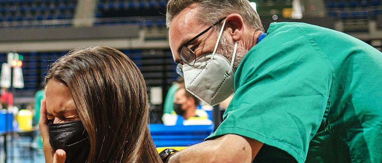 Un sanitario vacuna a una tinerfeña en el pabellón Santiago Martín de La Laguna.