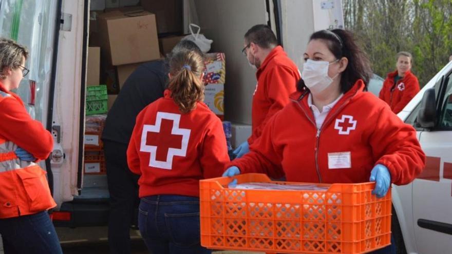 Una voluntaria de Cruz Roja traslada una caja con material de primera necesidad.