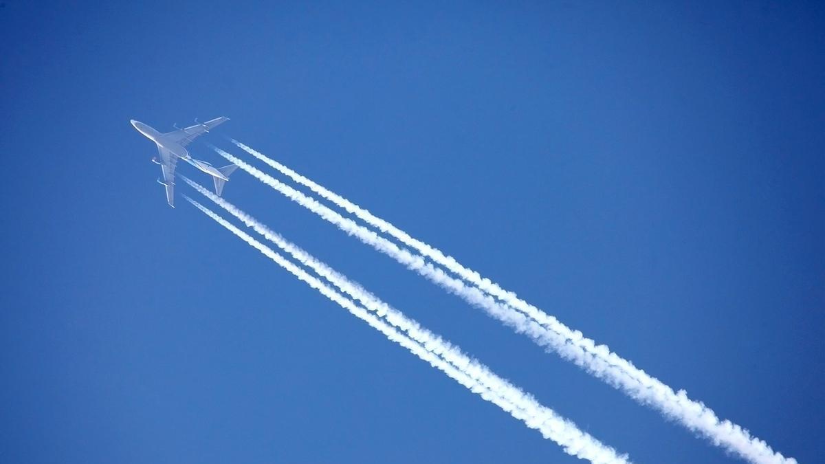 Un avión dejando estelas de condensación durante el vuelo