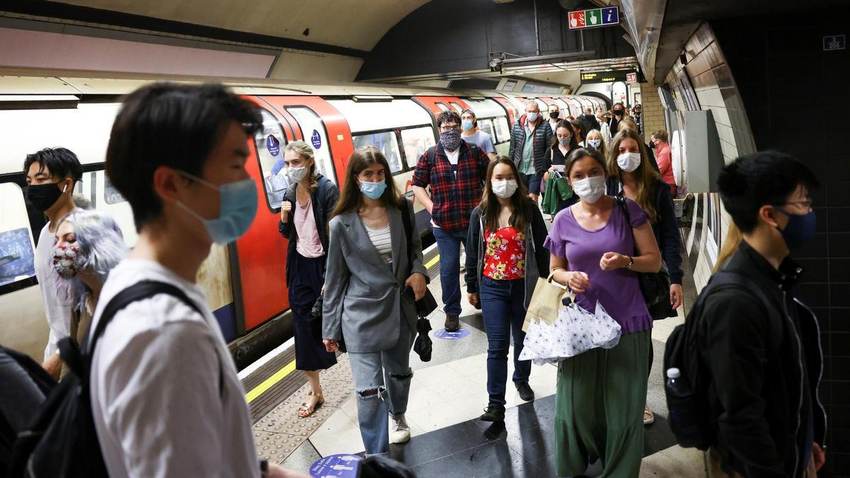 Gente con mascarilla en el metro de Londres.