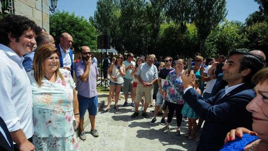 El conselleiro Rey Varela fotografía con el móvil a Touriñán. // I.Abella