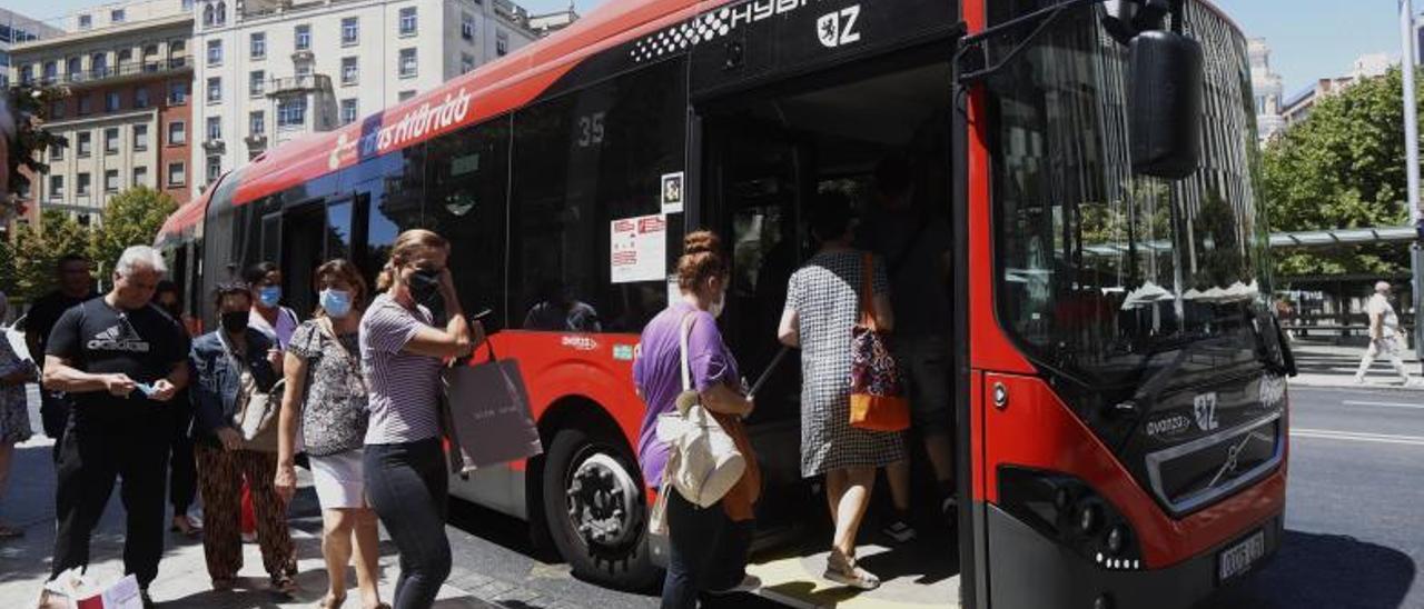 Varios usuarios accediendo a un autobús en la plaza España de Zaragoza, ayer.  | X