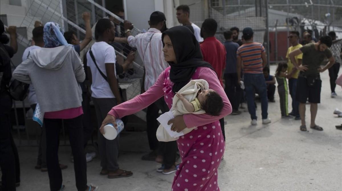 Una mujer sostiene a un bebé en el campo para refugiados que ACNUR tiene en la isla griega de Lesbos.