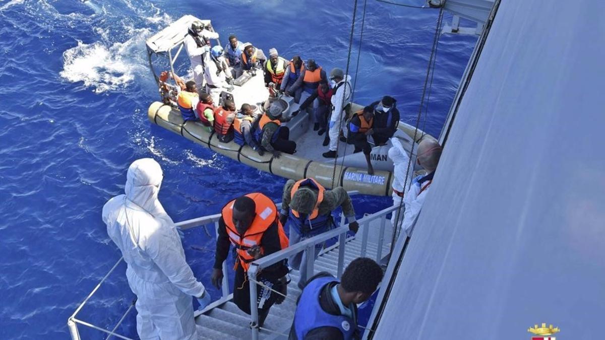 Un barco de la marina italiana rescata a un grupo de migrantes frente a las costas de Sicilia el lunes.