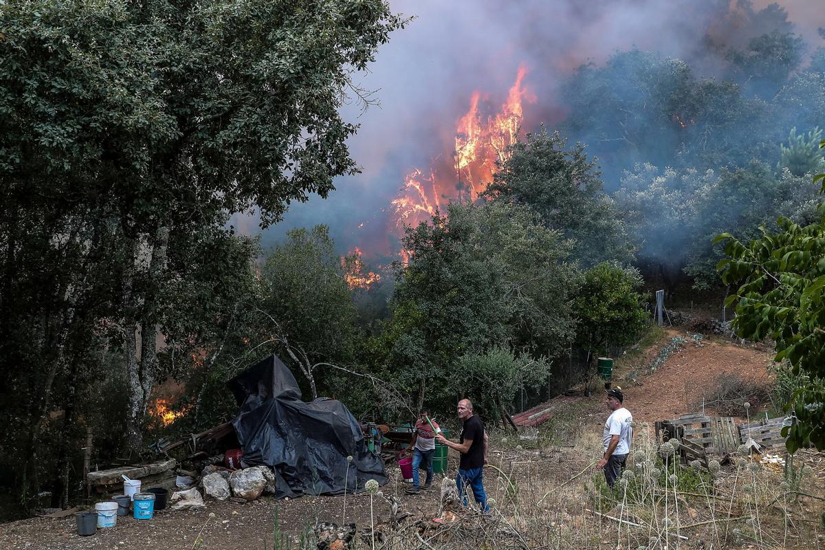 Vecinos combaten las llamas en el pueblo de Boavista, Ansião, durante la lucha contra el incendio que se inició en Abiul, Pombal, norte de Portugal, el 13 de julio de 2022. (Incendio) EFE/EPA/PAULO NOVAIS