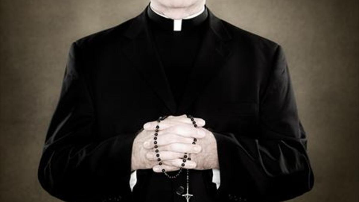 Un sacerdote sujeta un rosario.