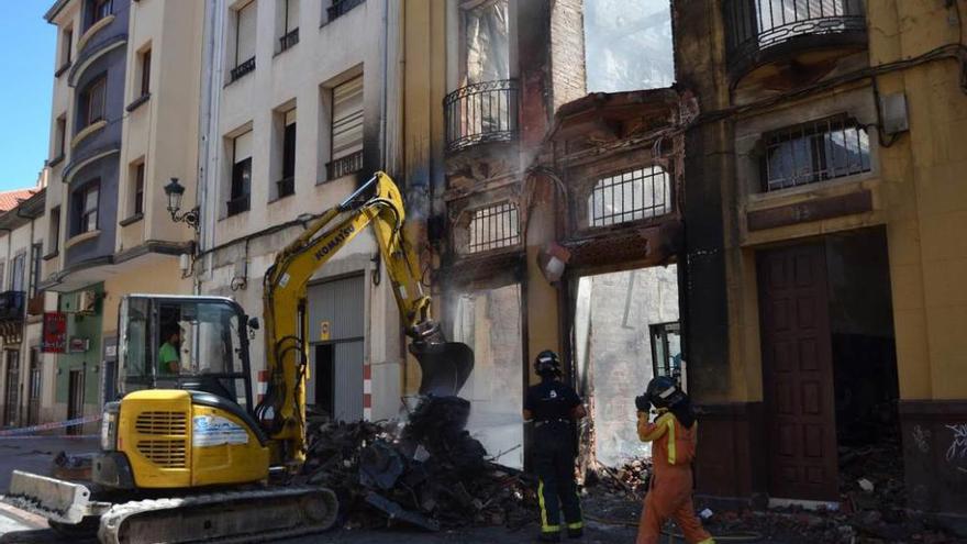 Los bomberos en las tareas de desescombro del edificio incendiado.