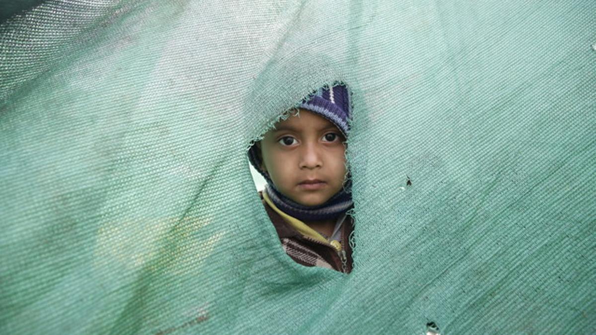 Una niña mira desde el agujero de una tienda en Katmandú, en el Nepal.