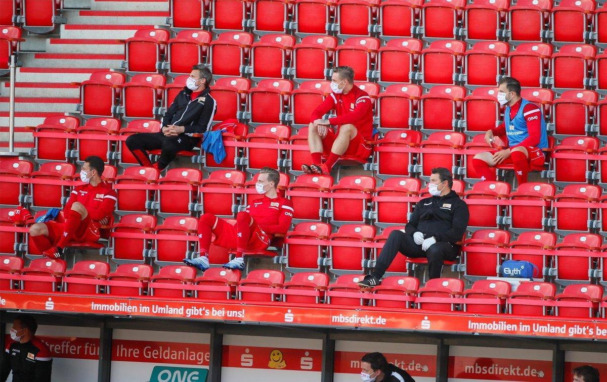 Los sustitutos del FC Union Berlin usan máscaras faciales y mantienen la distancia social en las gradas