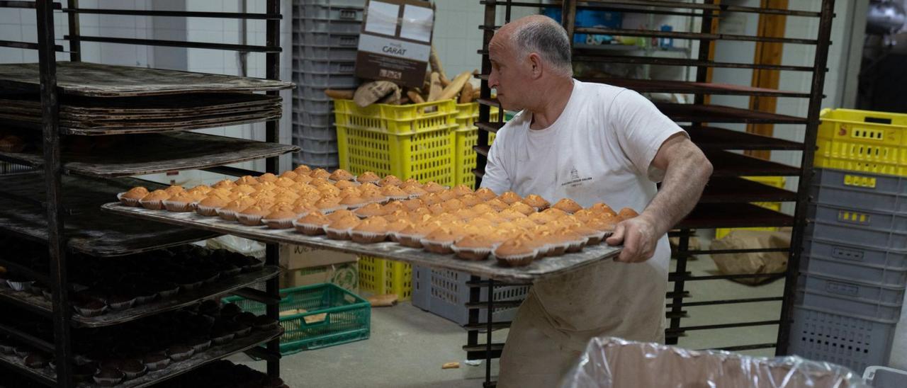 Un panadero del obrador de El Viso, en Villaralbo, saca una gran bandeja de magdalenas. | Emilio Fraile