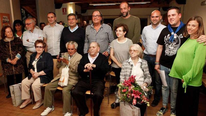 Los socios homenajeados, sentados, rodeados de familiares y representantes del Ayuntamiento.