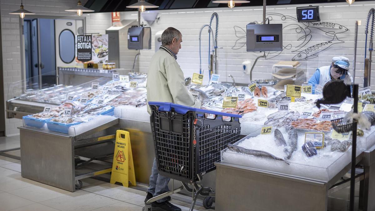 Un cliente compra en la pescadería de un supermercado Caprabo de Barcelona