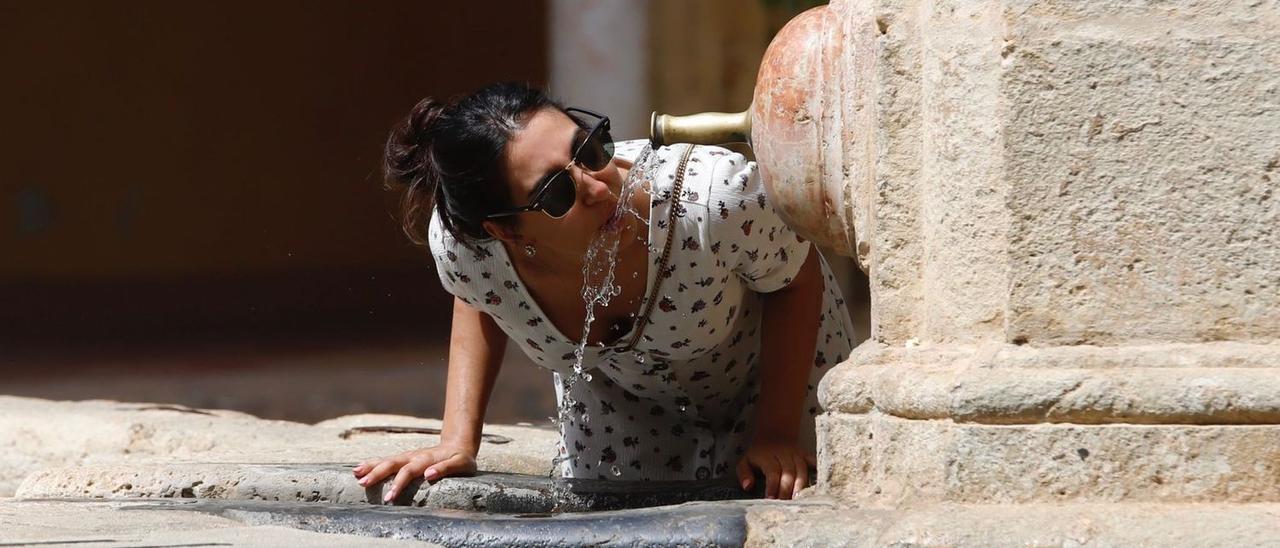 Una visitante se refresca en el Patio de los Naranjos de la Mezquita-Catedral.