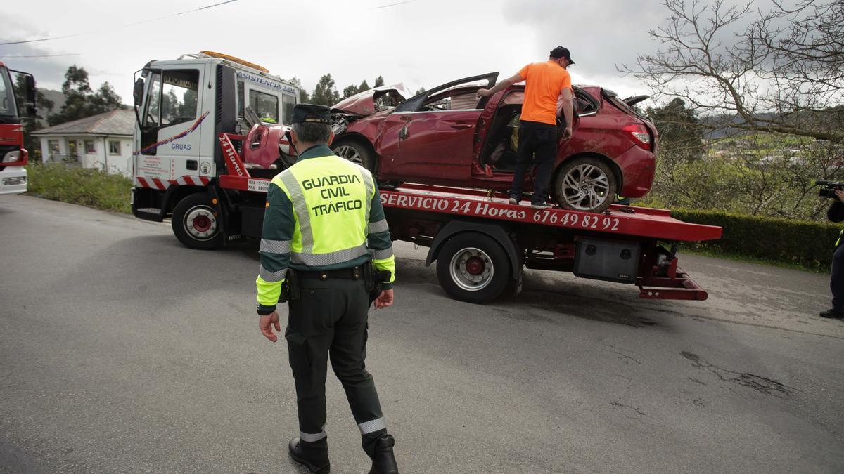 Un Guardia Civil vigila la retirada del coche siniestrado, en el accidente, por una grúa, a 1 de abril de 2023 en Xove (Lugo).