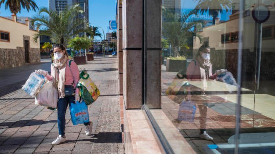 Una joven carga la compra en el centro de Santa Cruz de Tenerife.