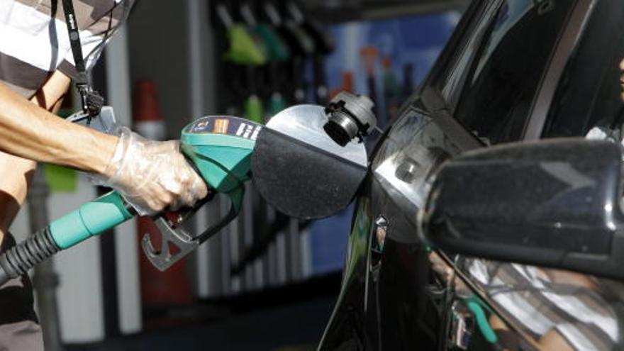 Un hombre llena el depósito de su coche.