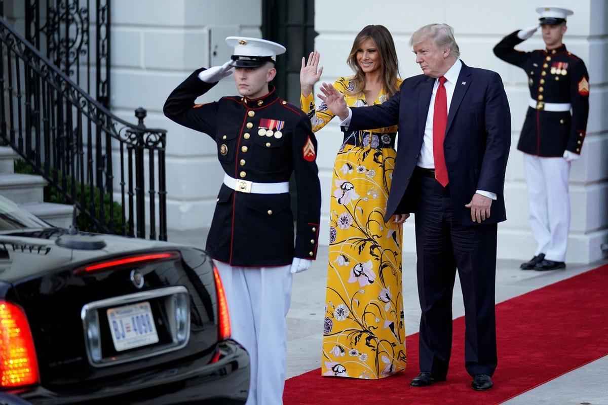 Melania Trump junto a su marido con un vestido largo con estampado