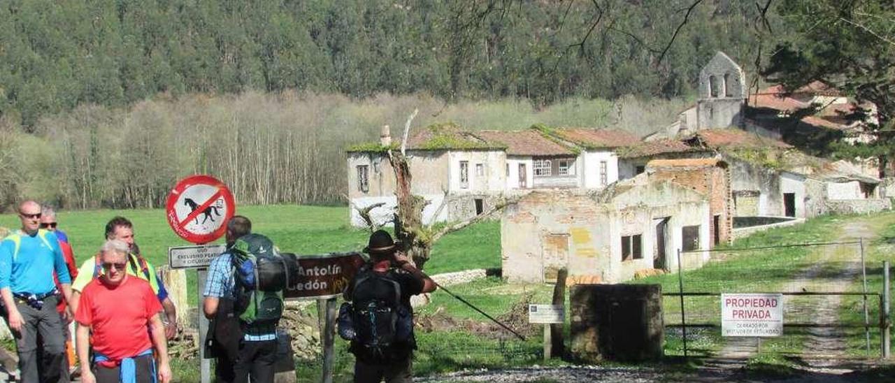 Varios peregrinos, ayer, junto al acceso a la finca y la iglesia de San Antolín de Bedón, cerrado al tránsito.