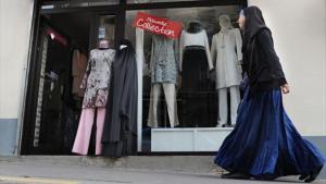 Una mujer con hijab pasa ante una tienda de moda para musulmanas en París.