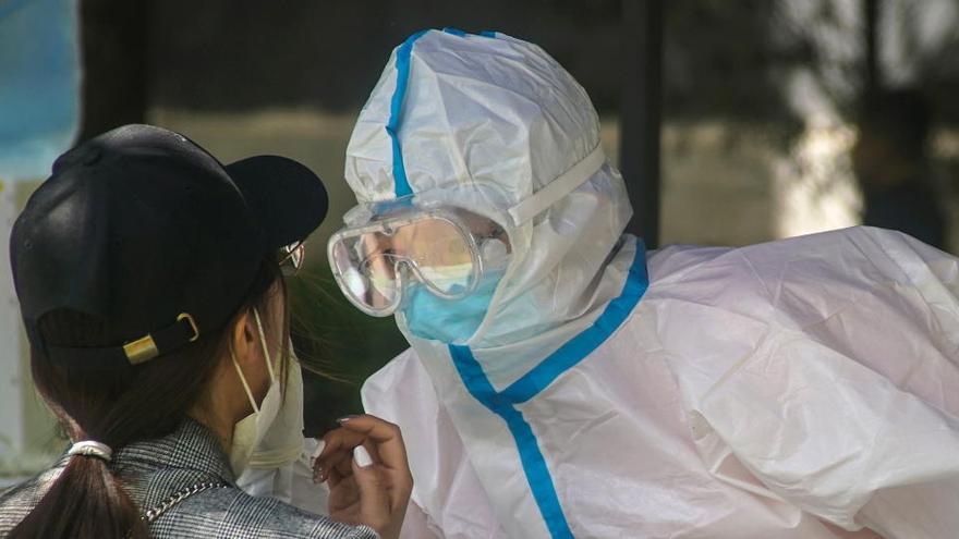 Un sanitario realiza un test a una mujer en Pekín.