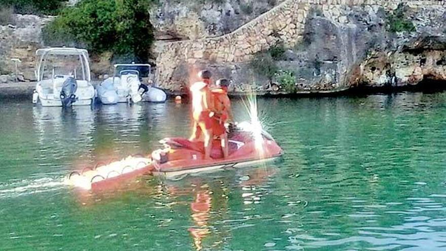 Un socorrista traslada al bañista, ayer en Cala Ferrera.