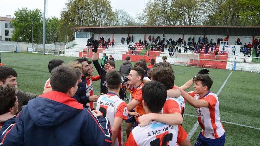 Jugadores y técnicos del Alondras festejan la permanencia en el campo de O Morrazo. // Gonzalo Núñez