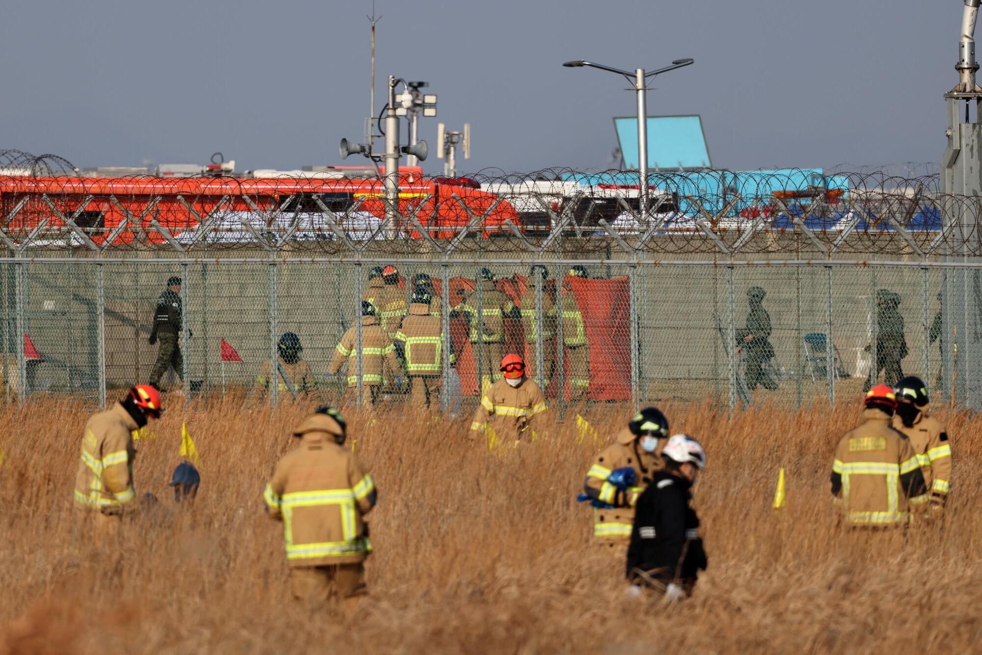 Muan (South Korea), 29/12/2024.- Firefighters search at the wreckage of the Jeju Air aircraft at Muan International Airport in Muan, 288 kilometers southwest of Seoul, South Korea, 29 December 2024. According to the National Fire Agency, a passenger jet carrying 181 people erupted in flames after going off the runway at an airport in South Korea's southwestern county of Muan on 29 December, leaving at least 176 people dead. (Corea del Sur, Seúl) EFE/EPA/HAN MYUNG-GU