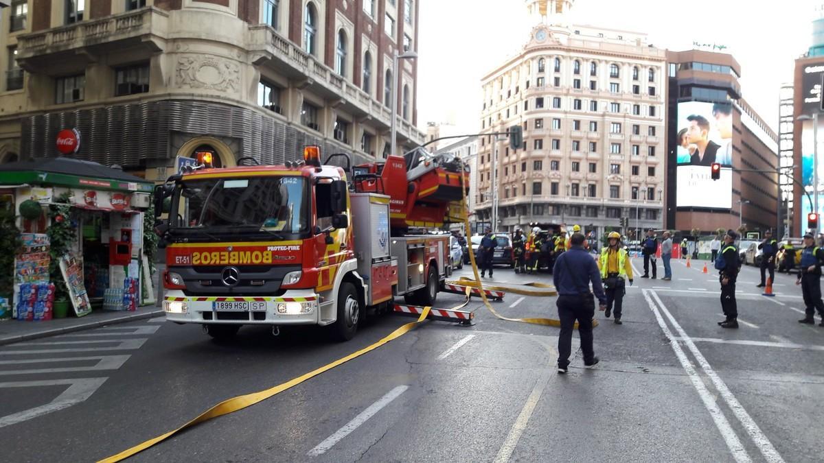 Servicios de emergencias para sofocar el incendio en el número 48 de la Gran Vía de Madrid, este lunes.