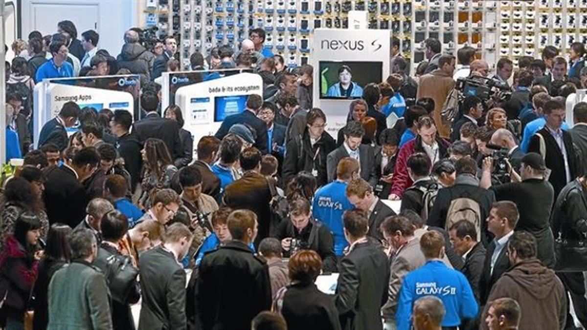 Decenas de asistentes prueban las novedades de la firma coreana Samsung en el Mobile World Congress de Barcelona.