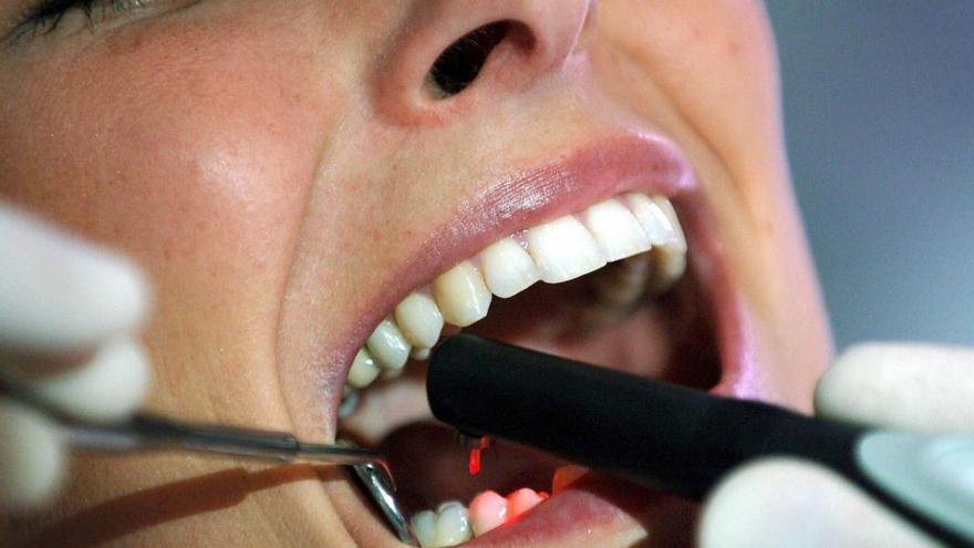 Una mujer es examinada por un dentista.