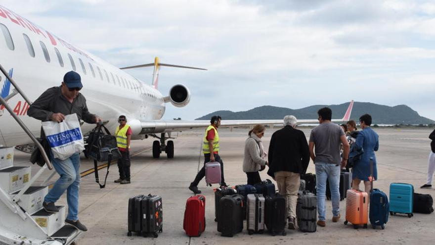 Un grupo de pasajeros desciende de un avión.