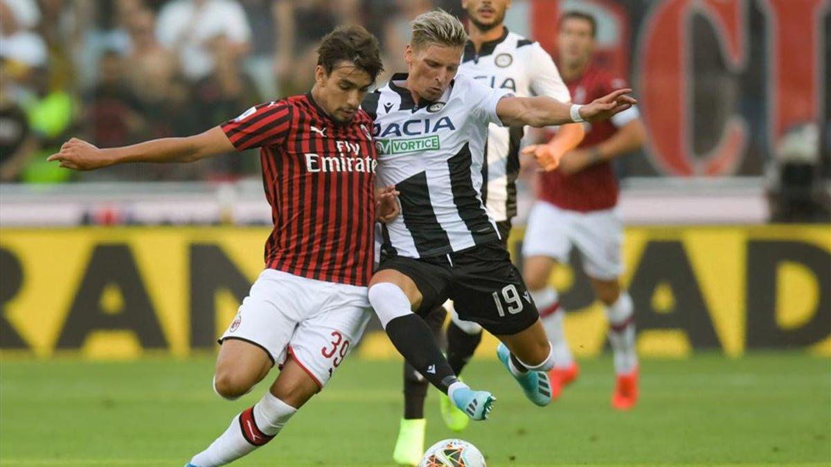 Disputa de un balón en el encuentro entre el Udinese y el Milán.
